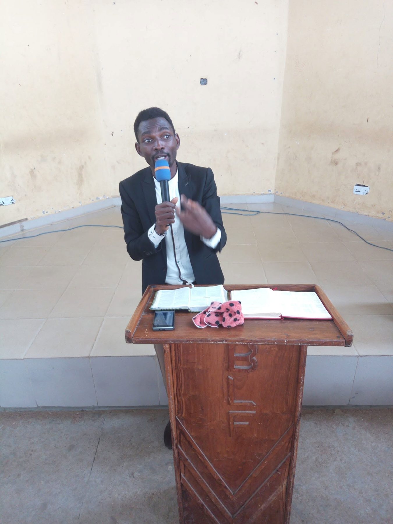 Pastor Popoola speaking from a pulpit