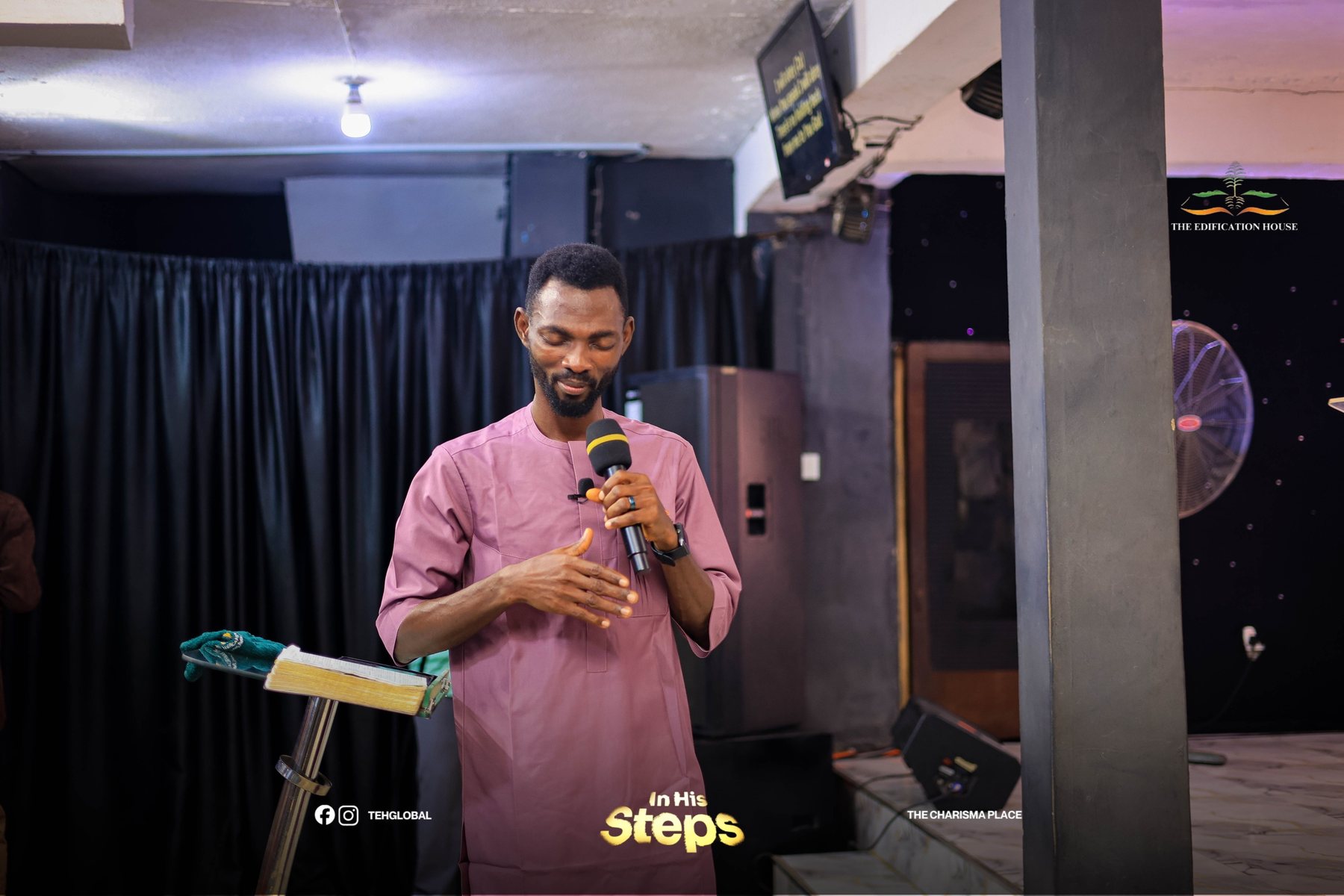 Pastor Popoola with eyes closed in prayer